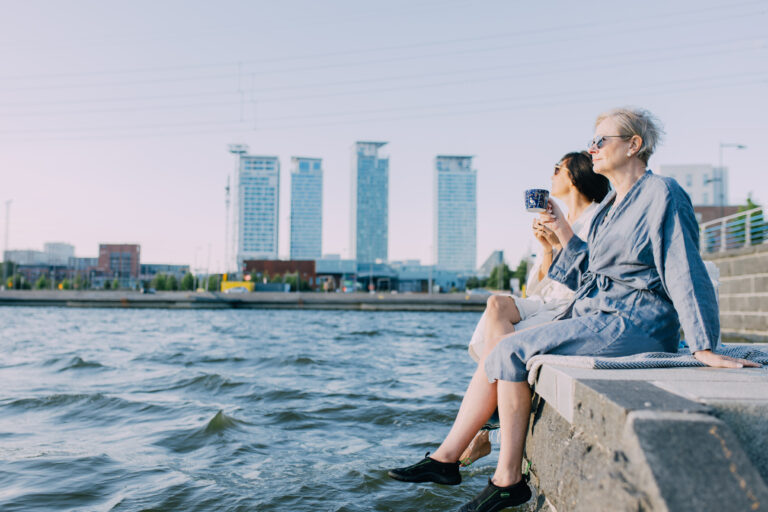 Persons sitting by the sea in Helsinki